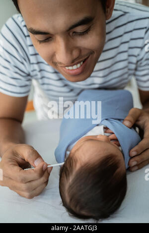 Liebevoller Vater baby girl Ohren gereinigt Stockfoto