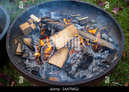 Ein kleines Feuer brennt in einer Feuerschale. Stockfoto