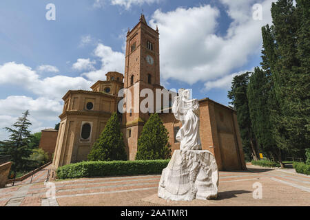 Alte Kirche auf dem Berg in der Toskana, Abbazia di Monte Oliveto Maggiore mit Statue und Straße Stockfoto