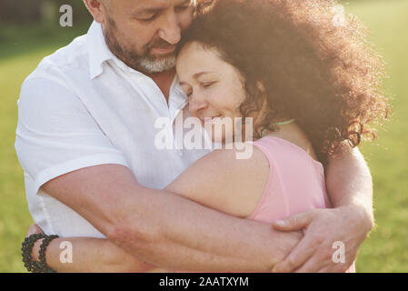 Eine liebevolle, stattlich senior Paar draußen im Park, viele Jahre zusammen Stockfoto