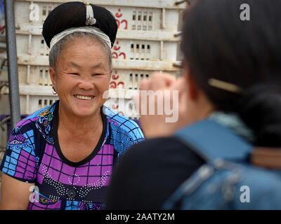 Japanische portrait Fotograf macht ein Foto von einer älteren Thai H'Mong Verkäuferin an lebhaften wöchentliche Mae Sariang der Markt am Samstag. Stockfoto