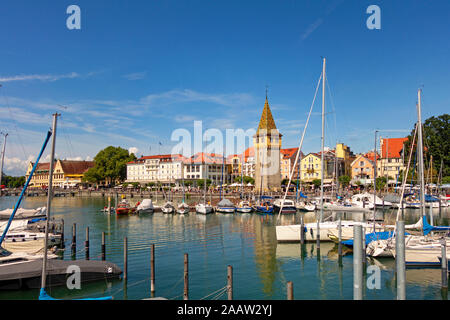 Boote im Hafen mit dem Gebäude im Hintergrund gegen den blauen Himmel, Lindau, Deutschland Stockfoto