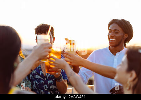 Glücklich, multi-ethnischen Freunde toasten Getränke Stockfoto