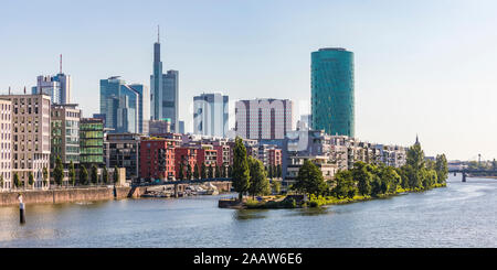 Gebäude und Westhafen Tower durch Fluss gegen den klaren Himmel in Frankfurt, Deutschland Stockfoto