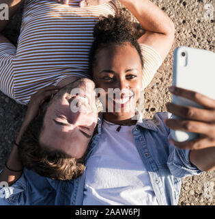 Glückliches junges Paar liegen auf Betonboden eine selfie Stockfoto