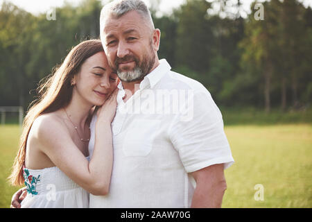 Ein älterer Mann umarmte seine erwachsene Tochter im Freien Stockfoto