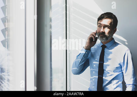 Reifen Geschäftsmann am Telefon im Büro Stockfoto