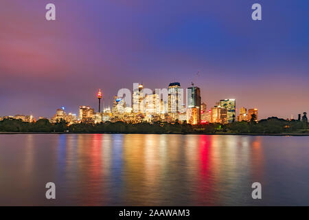 Beleuchtete Wolkenkratzer vor Fluss gegen Himmel bei Nacht, Sydney, Australien Stockfoto