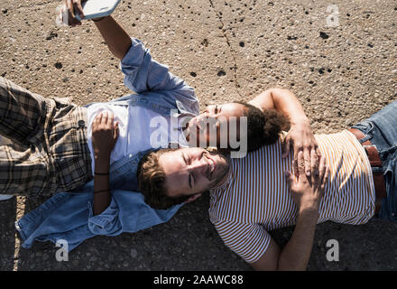 Glückliches junges Paar liegen auf Betonboden eine selfie Stockfoto