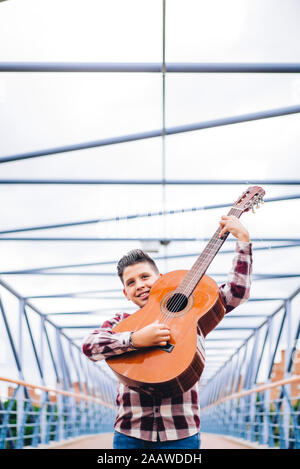 Zigeuner Junge spielt Gitarre auf einer Brücke Stockfoto