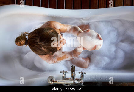 Frau spielen mit dem Schaum in der Badewanne, von oben