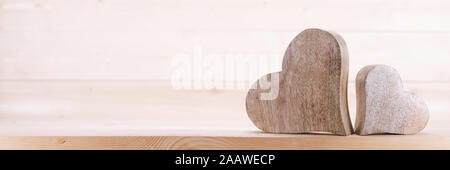 Zwei handgefertigt aus Holz geschnitzte Herz auf hellem Hintergrund paar Beziehung Valentinstag Konzept Stockfoto