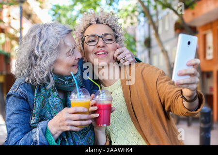 Ältere Mutter mit ihrer erwachsenen Tochter unter selfie in der Stadt Stockfoto