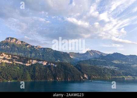 Schweiz, Gersau, Schwyz, malerischen Blick auf Wolken über den Vierwaldstättersee und hohen bewaldeten Klippen im Sommer Stockfoto