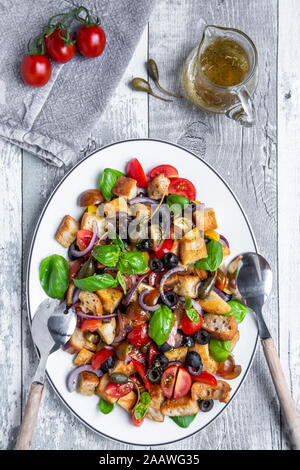 Panzanella Italienischer Salat mit geröstetem ciabatta Brot, Tomaten, Oliven, rote Zwiebel, Kapern Äpfel und Basilikum auf Platte Stockfoto
