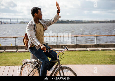 Junger Mann reiten Fahrrad am Meer Stockfoto