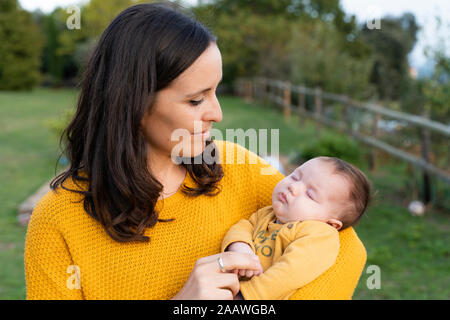 Mutter halten Schlafen Baby Mädchen in Ihre Arme Stockfoto