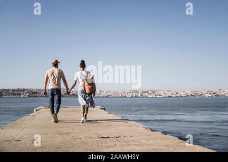 Junges Paar zu Fuß auf Pier an der Waterfront, Lissabon, Portugal Stockfoto