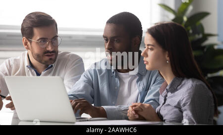 Ernsthafte multiethnischen Mitarbeiter Brainstorming im Büro mit Laptop Stockfoto