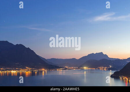 Schweiz, Gersau, Schwyz, beleuchtete Häuser entlang der Küste des Vierwaldstättersees in der Dämmerung Stockfoto