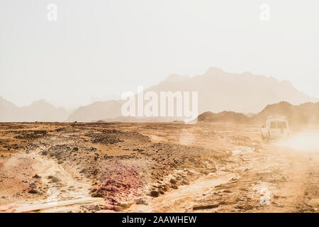 Off Road Fahrzeug bewegt sich auf trockene Landschaft gegen den klaren Himmel während der sonnigen Tag bei Suez, Ägypten Stockfoto