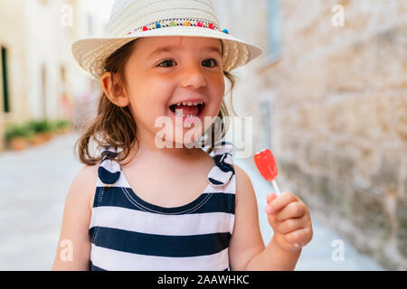 Portrait von glücklichen kleinen Mädchen mit roten Lutscher im Sommer Stockfoto