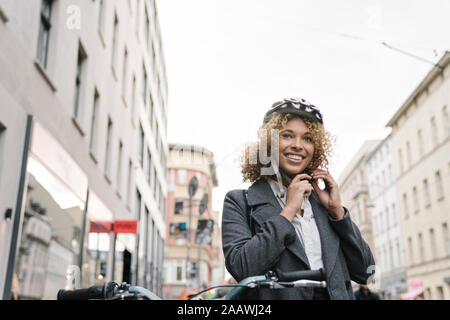 Frau auf Fahrrad Helm in der Stadt, Berlin, Deutschland Stockfoto
