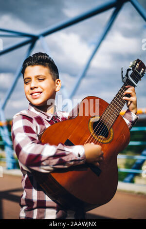 Zigeuner Junge spielt Gitarre auf einer Brücke Stockfoto