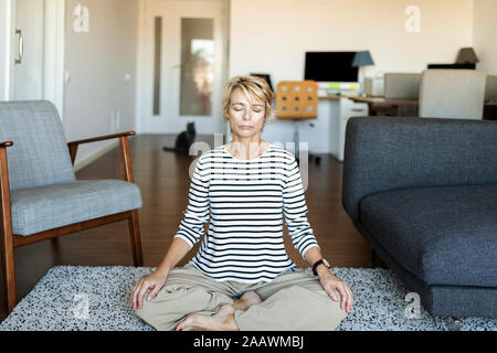 Reife Frau Yoga zu Hause Stockfoto