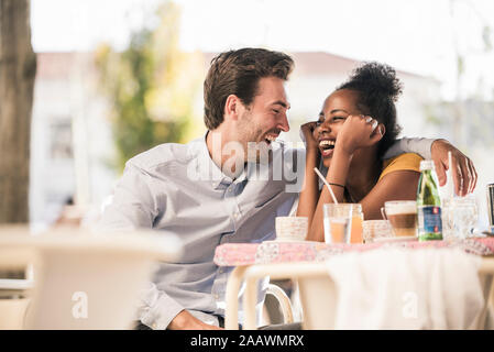 Lachen junges Paar an ein Café im Freien Stockfoto