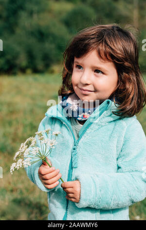 Portrait von lächelnden Mädchen mit Wildblumen im Herbst Stockfoto