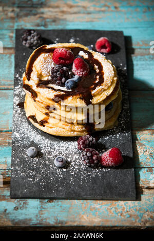 Pfannkuchen mit Schokolade Sauce und verschiedenen Beeren auf Tisch Stockfoto