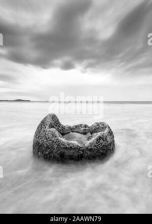 Moeraki Boulder im Meer am Strand gegen Koekohe bewölkter Himmel, Neuseeland Stockfoto