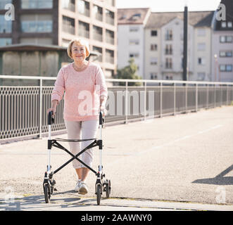 Ältere Frau mit rollator auf Steg Stockfoto