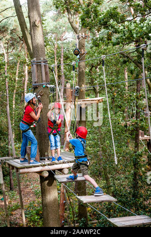 Familie auf einem Hochseilgarten im Wald Stockfoto