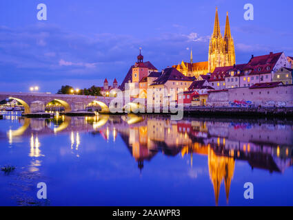 Steinbrücke über die Donau in beleuchtete Stadt in der Dämmerung, Regensburg, Oberpfalz, Bayern, Deutschland Stockfoto