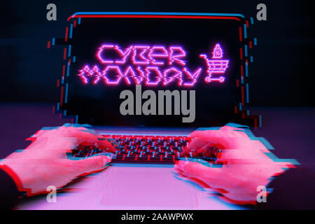 Man Spieler neben Laptop mit Bildschirm auf schwarzem Hintergrund, rosa Inschrift. Cyber Monday Stockfoto