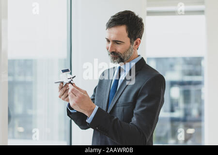 Lächelnd reife bussinessman Holding space shuttle Modell Stockfoto