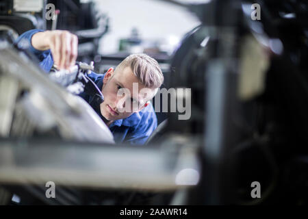 Junger Mann die Einstellung einer Maschine in einer Druckerei Stockfoto