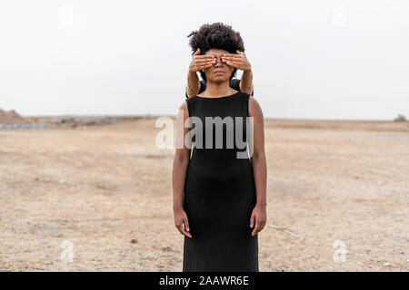 Woman's Hände, die Augen der anderen Frau, die in der kargen Landschaft Stockfoto