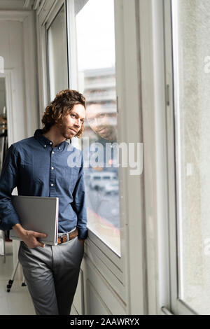 Mann hält Ordner in einem Studio Blick aus Fenster Stockfoto