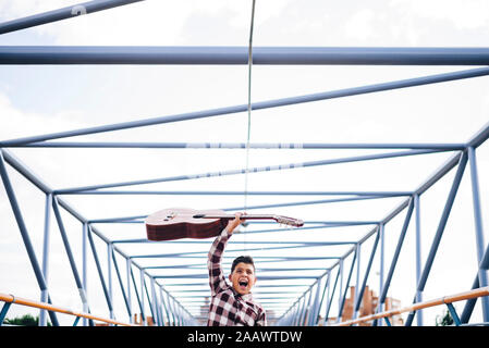 Zigeuner Junge mit Gitarre auf einer Brücke Stockfoto