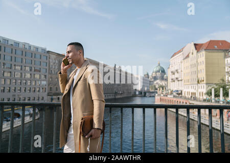 Geschäftsmann am Telefon steht auf einer Brücke, Berlin, Deutschland Stockfoto