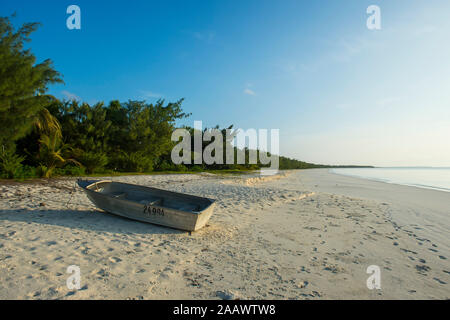 Boot vertäut am White Sand Beach bei Sonnenuntergang, Ouvea, Loyalität, Inseln, Neukaledonien Stockfoto