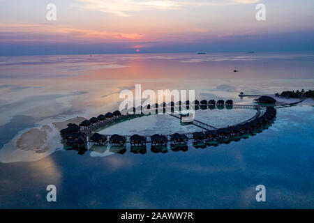 Luftaufnahme der Pfahlbauten auf Olhuveli Insel bei Sonnenaufgang auf den Malediven Stockfoto