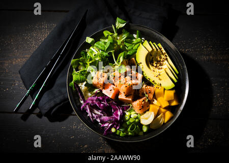 Direkt oberhalb der Schuß von poke Schüssel mit Stäbchen auf hölzernen Tisch Stockfoto