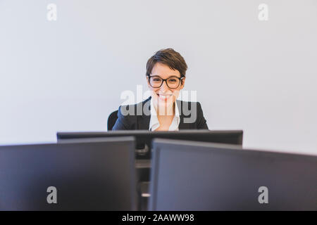 Portrait von lächelnden Jungen geschäftsfrau am Schreibtisch im Büro Stockfoto