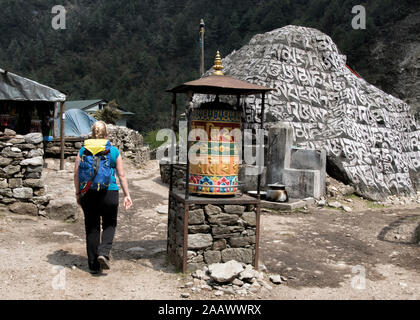 Junge Frau vorbei Gebetsmühle, Manjo, Solo Khumbu, Nepal Stockfoto