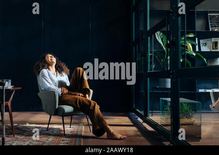 Junge Geschäftsfrau entspannen im Loft Büro Stockfoto
