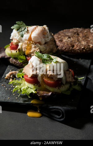 Nahaufnahme der offenen konfrontiert Sandwich auf Tisch auf schwarzem Hintergrund Stockfoto